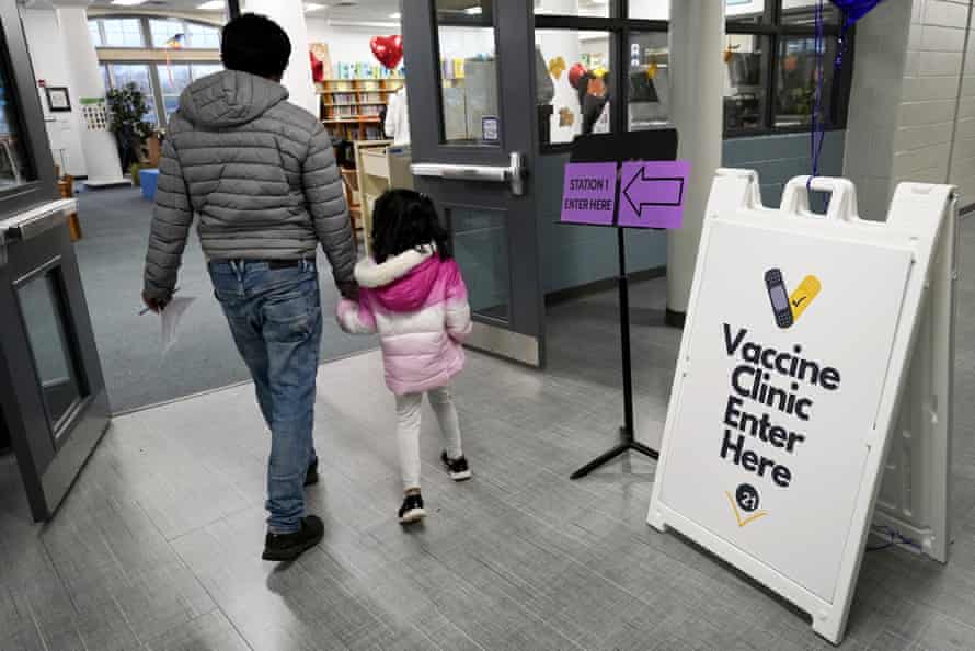 A parent and child walk in to a Covid vaccine clinic in Wheeling, Illinois, on 17 November.