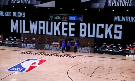 Referees stand on an empty court after a scheduled game between the Milwaukee Bucks and the Orlando Magic was cancelled when the players agreed to boycott. 