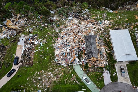 Aerial view of destroyed houses on residential street, debris filling the yards