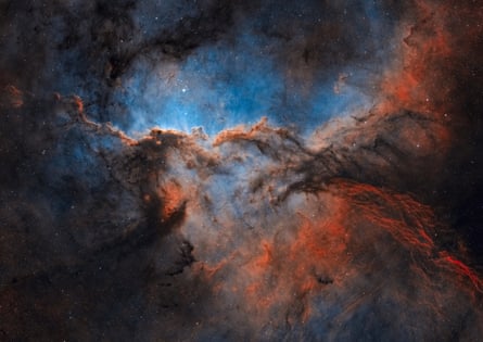 A blue and orange sky with swirls of black and grey clouds