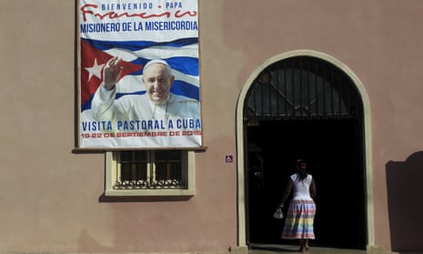 A woman enters a church with a poster advertising the visit of Pope Francis to Cuba in Santiago de las Vegas, Cuba, on Tuesday.