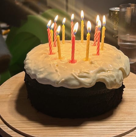 A dark chocolate cake with a lush creamy topping starting to spill down the sides