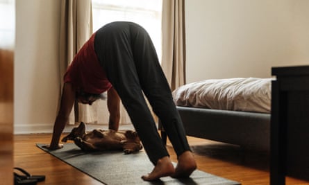 Aşağıya bakan köpek yogası yapan adam, kendisine bakan küçük köpeğin üzerinde poz veriyor