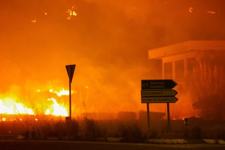 A wall of flame approaches a building
