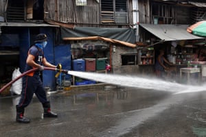 A firefighter disinfects the street in Santa Ana district, in Manila City.