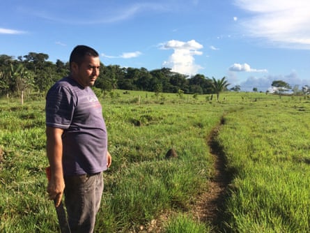 Vergara in his pasture. The termite mounds are evidence of poor soil quality to grow the grasses for cattle, Colombia