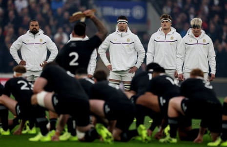 England players look on as New Zealand players perform the Haka.