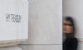 a blurred slow-shutter photo of the HM Treasury sign with a woman peering at the camera (face blurred)