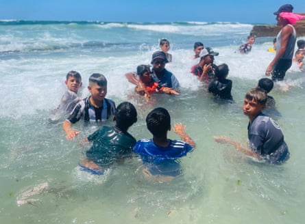 A group of children in shallow water on a beach