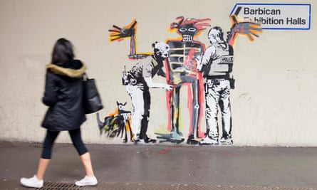 A woman passes one of the Banksy murals near the Barbican Centre.