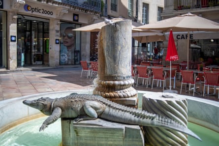 A crocodile on a fountain in a Nîmes city square