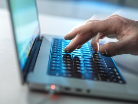 مردی که در دفتر روی لپتاپ تایپ میکند