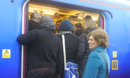 People attempt to get on the train at Hornsey station.