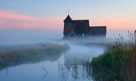 Church on riverside in mist, with lots of sheep