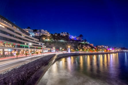 Seafront properties and promenade illuminated at night