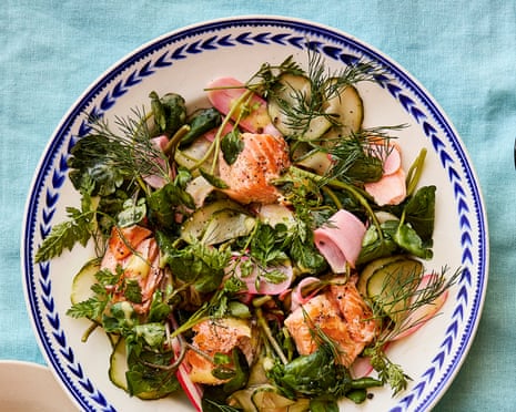 A spread of Max Rocha's trout watercress pickled cucumber radish and mustard salad arranged with a fork and peppermill on a blue tablecloth.