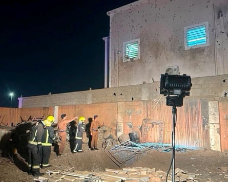 Members of security forces and emergency personnel inspect a damaged site in the aftermath of Houthi strikes.