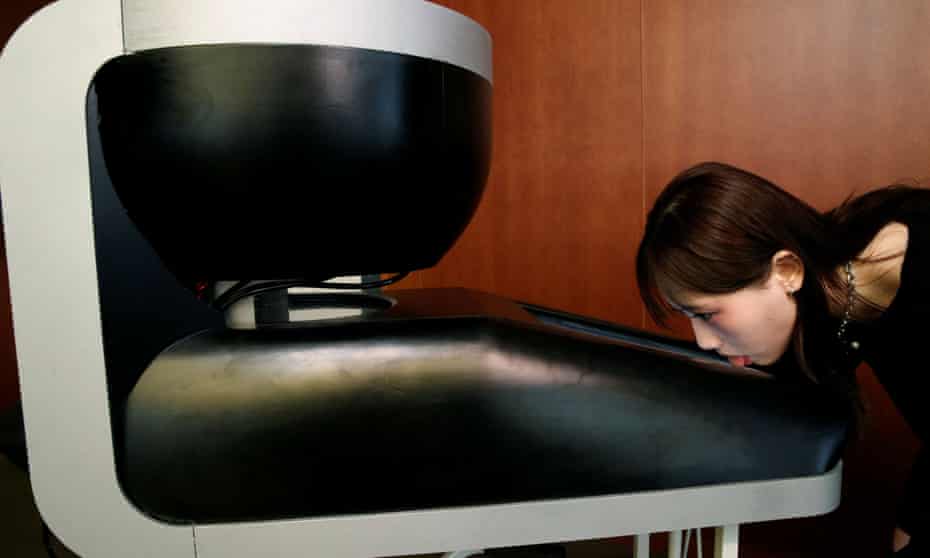 Yuki Hou, a student at Meiji University in Tokyo, demonstrates the Taste the TV lickable screen.