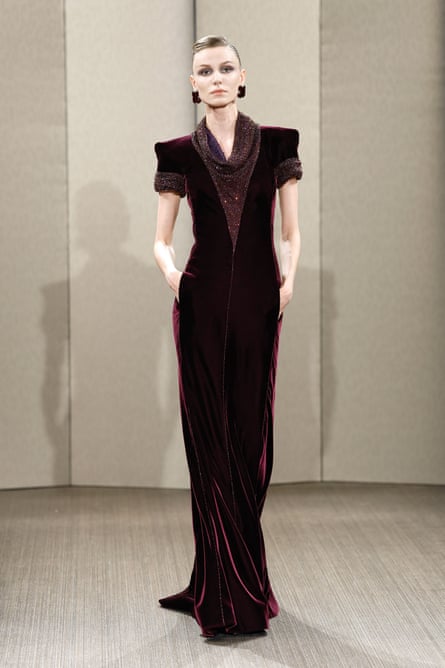 A model at Armani Privé haute couture in a black short-sleeved gown with sculpted shoulders.