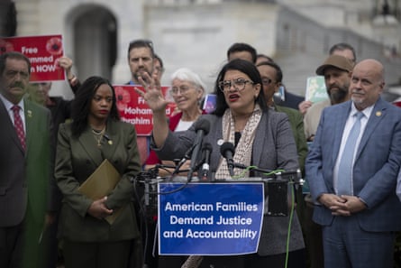 a woman speaks into a microphones at a lectern with a sign that reads ‘American families demand justice and accountability’