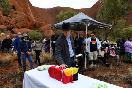 Author of Return to Uluru, Mark McKenna, places his hand on Yukun’s remains as Paddy Uluru’s grandson, Sammy Wilson (right), watches on.