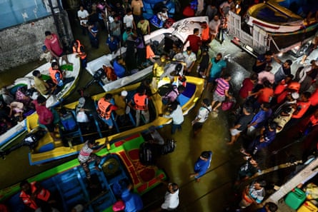 Rescue personnel evacuate people on boats belonging to Sri Lanka's army on a flooded street in Wellampitiya on the outskirts of Colombo on Sunday.