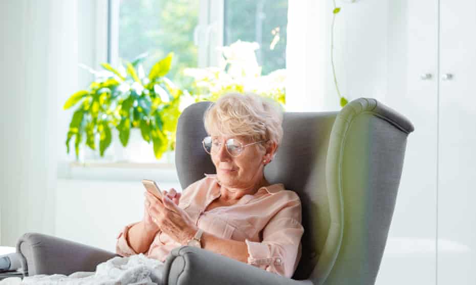 Elderly lady using a smart phone in her room.