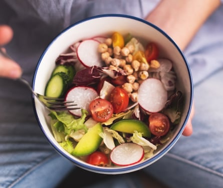 A vegan breakfast bowl with spinach, rocket, avocado, seeds, radishes and sprouts.