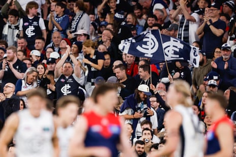 Carlton fans wave flags in the stands