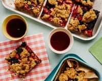 Brown butter apple and blackberry bars on a trap, with some in a lunchbox and some on a napkin, and drinks alongside