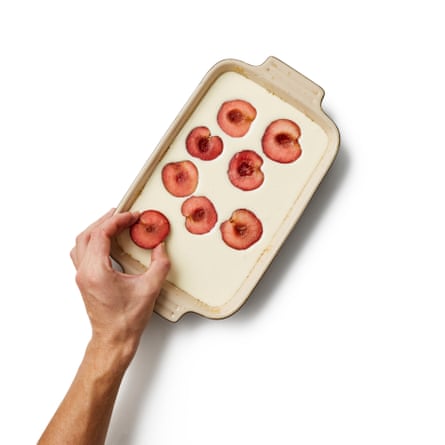 Put the batter in the tray. Put the fruit halves in the batter.