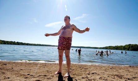 Richard Kind on the beach in swim shorts and a goofy grin in a still from A Serious Man