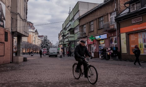 A man on a bicycle on a shopping street