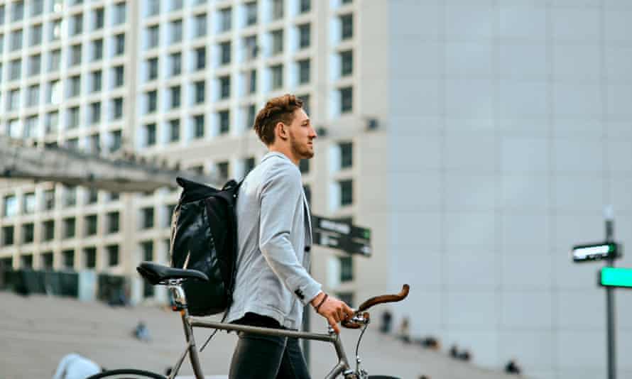 Shot of a young businessman traveling through the city with his bicycle.