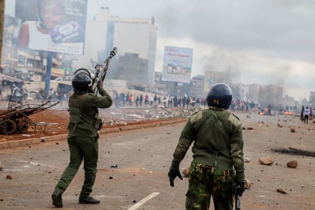 Riot police fire teargas towards protesters down a wide street