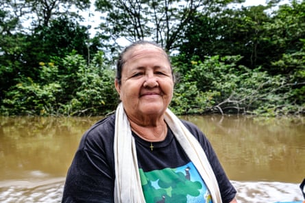 An older Hispanic woman sitting on a boat smiles at the camera