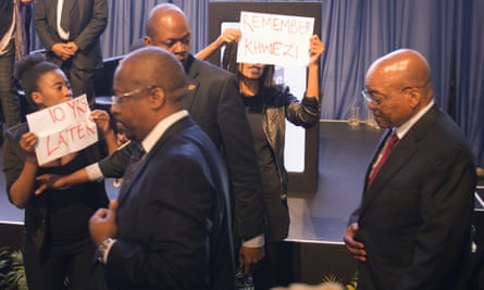 Security guards escort Zuma paast the protesters.