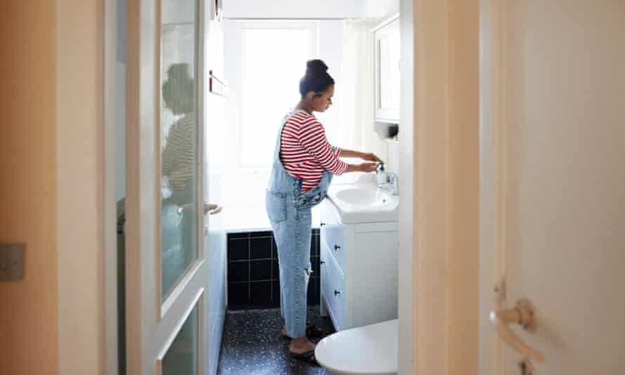 A pregnant woman washing her hands in a bathroom