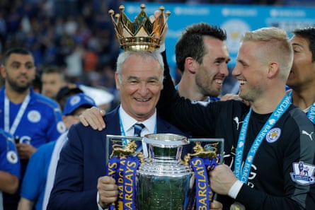 Claudio Ranieri poses with the Premier League trophy while Kasper Schmeichel puts the crown on the manager’s head