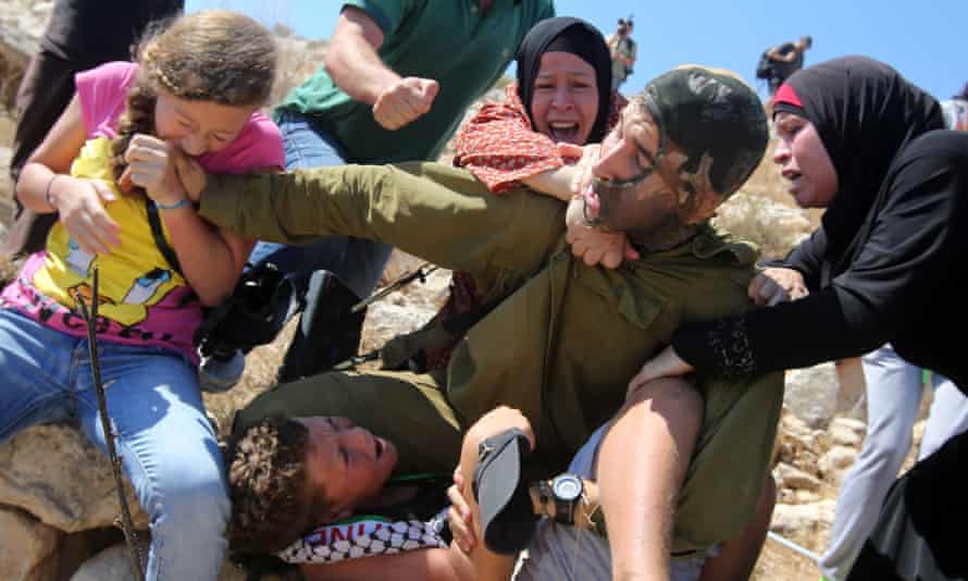 Ahed Tamimi bites the soldier’s hand.