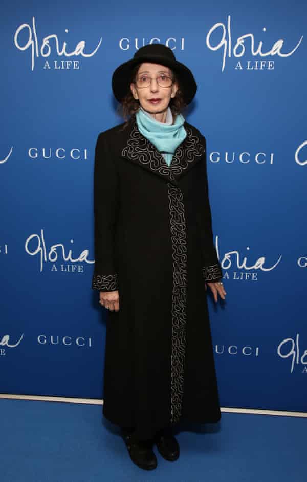 Joyce Carol Oates in a smart hat and coat posing for photographs on the way into an event