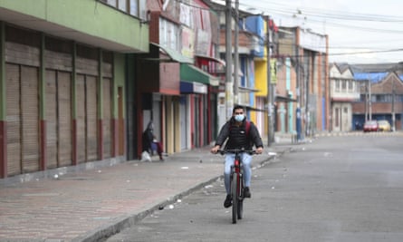 A man cycles past shuttered businesses during a strict lockdown in Bogota, Colombia.
