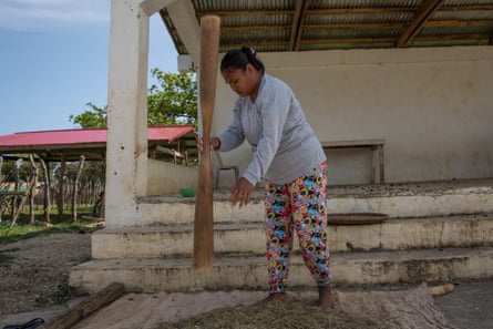 A woman pounds rice grown on Fuga Island