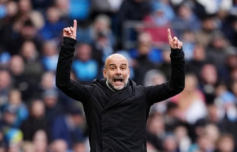 Pep Guardiola smiling, arms raised and pointing upwards with his index fingers