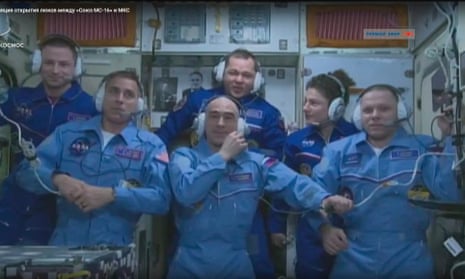 Andrew Morgan, Oleg Skripocha and Jessica Meir pose behind their replacement crew onboard the International Space Station.