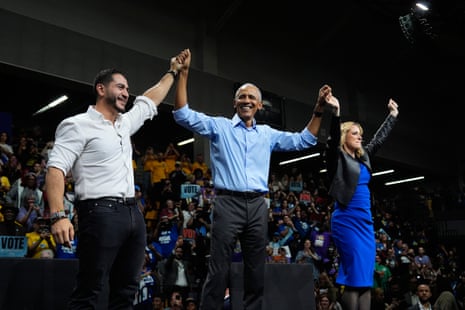 Obama, El-Sayed and Benson stand together on stage with their hands raised