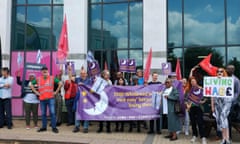 Protest outside the annual shareholder meeting:a group of people hold union flags, banners and signs including one calling for a living wage.