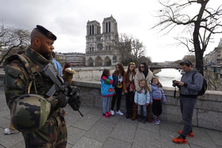 French soldier patrols as people arrive for the Easter mass at Notre Dame Cathedral in Paris