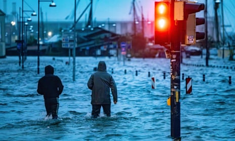 People making their way across a flooded street in Flensburg, northern Germany on Friday.