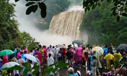 Tourists visit Huangguoshu Waterfall amid heavy rain in Anshun, Guizhou province on Tuesday.
